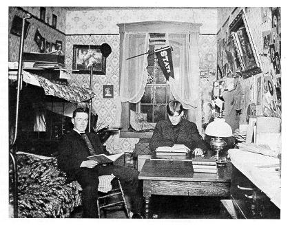old black and white photograph of students in cluttered dorm room