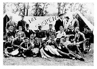 old black and white photograph of students posing at campsite