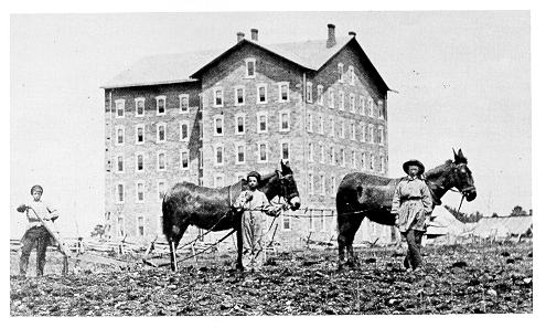 Photograph of students doing farm work in front of the unfinished Main Building, 1860.