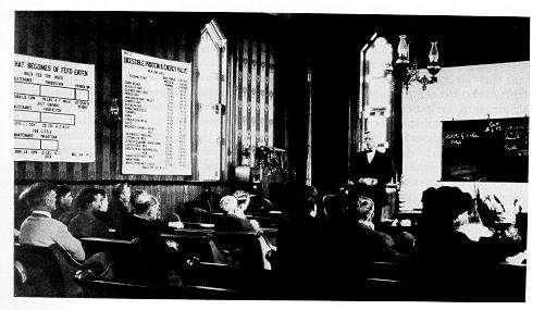 old photograph of a county agent speaking to farmers at a country church. 