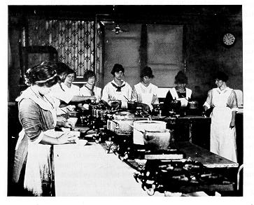 old black and white photograph of  female students cooking on gas stoves