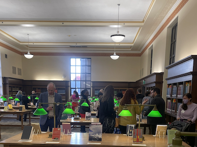 2022 promation and tenure reception with people gathered in the Paterno Reading Room enjoying refreshments and reviewing book selections of honorees